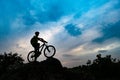 Silhouette of Cyclist with Mountain Bike on Rock at Sunset. Extreme Sports and Enduro Cycling Concept. Royalty Free Stock Photo