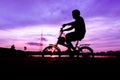 Silhouette of cyclist ride bike on road at sunset