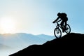 Silhouette of Cyclist Riding the Bike Down the Rock at Sunrise. Extreme Sport and Enduro Biking Concept. Royalty Free Stock Photo