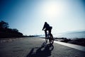 Cyclist riding bike in the sunrise coast road