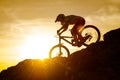 Silhouette of Cyclist Riding Down the Mountain Bike on Rocky Hill at Sunset. Extreme Sport Concept. Royalty Free Stock Photo