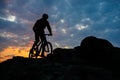 Silhouette of Cyclist Riding Mountain Bike on the Spring Rocky Trail at Beautiful Sunset. Extreme Sports and Adventure Concept. Royalty Free Stock Photo