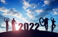 Silhouette of cyclists with bicycles at sunset. Forward to the New Year 2022. Royalty Free Stock Photo