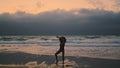 Silhouette dancer performing contemporary style at dramatic cloudy sky on beach. Royalty Free Stock Photo