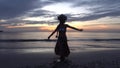 Silhouette of a dancing girl against the sunset background â