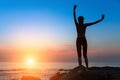 Silhouette of dancing slim woman on the ocean coast during an amazing sunset. Royalty Free Stock Photo