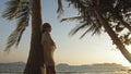 Woman drinking pineapple cocktail Pina Colada near palm tree, in white shirt, sunglasses. Concept rest tropical sea Royalty Free Stock Photo