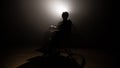 Silhouette dark man on wheelchair at mystery stage . video production and cinematography with film led light at background .