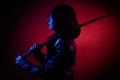 woman with a bob hairstyle in a black leather jacket with a katana in her hands, posing  on a dark background Royalty Free Stock Photo