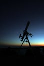 silhouette of telescope on the mountain at the sky sunrise. Image contain certain grain or noise and soft focus. Royalty Free Stock Photo