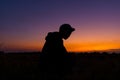 Silhouette dark young man wearing a hat standing emotions with evening Twilight sky with cloud in the winter season at sunset