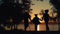 Silhouette daughter couple running at river sunset view. Caring people together. Royalty Free Stock Photo