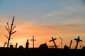 Silhouette of decayed graveyard with tilted crosses and tombstones in sunset light Royalty Free Stock Photo