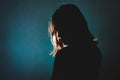 Silhouette of depress woman standing in the dark with light shin Royalty Free Stock Photo