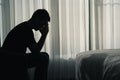 Silhouette depressed man sadly sitting on the bed in the bedroom Royalty Free Stock Photo