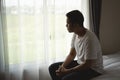 Silhouette depressed man sadly sitting on the bed in the bedroom. Sad asian men suffering depression insomnia awake and sit alone Royalty Free Stock Photo