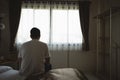 Silhouette depressed man sadly sitting on the bed in the bedroom. Sad asian men suffering depression insomnia awake and sit alone Royalty Free Stock Photo
