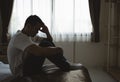 Silhouette depressed man sadly sitting on the bed in the bedroom. Sad asian men suffering depression insomnia awake and sit alone Royalty Free Stock Photo