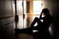 Silhouette of depressed man sitting on walkway of residence building. Sad man, Cry, drama, lonely and unhappy concept Royalty Free Stock Photo