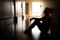 Silhouette of depressed man sitting on walkway of residence building. Sad man, Cry, drama, lonely and unhappy concept Royalty Free Stock Photo