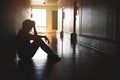 Silhouette of depressed man sitting on walkway of residence building. Sad man, Cry, drama, lonely and unhappy concept Royalty Free Stock Photo