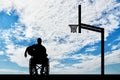 Silhouette of a disabled basketball player in a wheelchair holding the ball in his hand Royalty Free Stock Photo