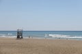 Silhouette of a distant anonymous tourist on the background of the sea on the sandy coast near the wavy sea during the