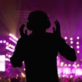 Silhouette of DJ wearing headphones and performing at a night club Royalty Free Stock Photo