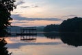 Silhouette of a dock on a lake before dawn under a purple sky in summer Royalty Free Stock Photo