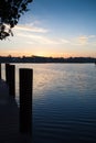 Silhouette of dock pilings over water and sunrise