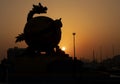 Silhouette of a dragon sculpture during golden hour