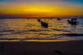 Silhouette dramatic view of shiny seascape over sunset sky with fishing boats Royalty Free Stock Photo