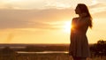 Silhouette of dreamy girl in a field at sunset, a young woman in a haze from the sun enjoying nature, romantic style Royalty Free Stock Photo