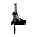 Silhouette of a drilling rig with a drill bit penetrating the ground Royalty Free Stock Photo