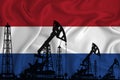 Silhouette of drilling rigs and oil derricks on the background of the flag of Netherlands. Oil and gas industry. The concept of