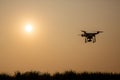 Silhouette drone against the background of the sunset. Flying drones in the evening sky.