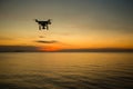 Silhouette drone against the background of the sunset. Flying drones in the evening sky. UAV Drone with digital camera.