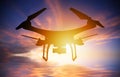 Silhouette of drone with digital camera flying in a sunset sky Royalty Free Stock Photo