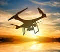 Silhouette of a drone with digital camera flying in a sunset sky Royalty Free Stock Photo