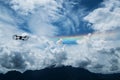 Silhouette drone flying on blue sky with rainbow