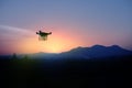 Silhouette of drone flying to the mountain view at sunset Royalty Free Stock Photo