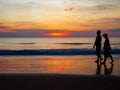 Silhouette of Elderly couple walking on beach against backdrop beautiful sunset Royalty Free Stock Photo