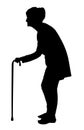 Silhouette of Elderly woman with bent back walking with cane