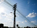 Silhouette Electric pole connect to the high voltage electric wires on sunlight blue sky. Structure line wire power electrical. Royalty Free Stock Photo