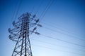 Silhouette of electrical pylon over light blue sky