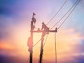 Silhouette electrical workers are installing high voltage system