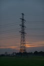 Silhouette of electricity pylon at sunset with orange clouds Royalty Free Stock Photo