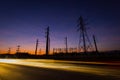 Silhouette electricity pylons and power plant with light trails Royalty Free Stock Photo