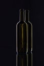 Silhouette of elegant and very old wine bottles on a glass desk Royalty Free Stock Photo