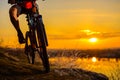 Silhouette of Enduro Cyclist Riding the Mountain Bike on the Rocky Trail at Sunset. Active Lifestyle Concept. Space for Text.